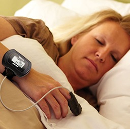 Woman sleeping with apnea testing device